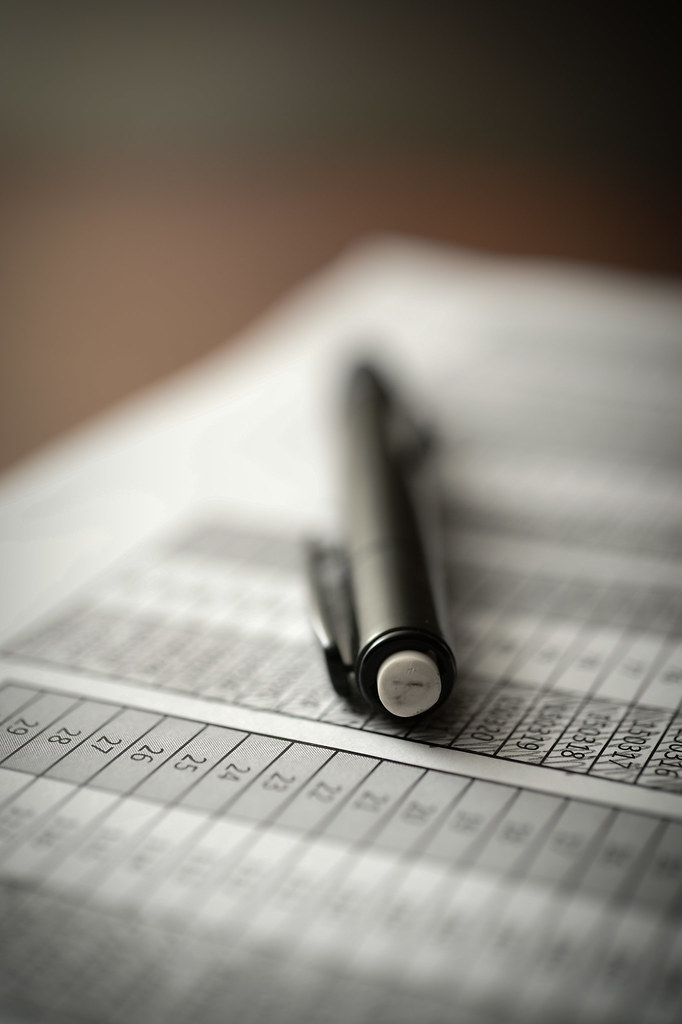 A mechanical pencil resting on a printed table of figures
