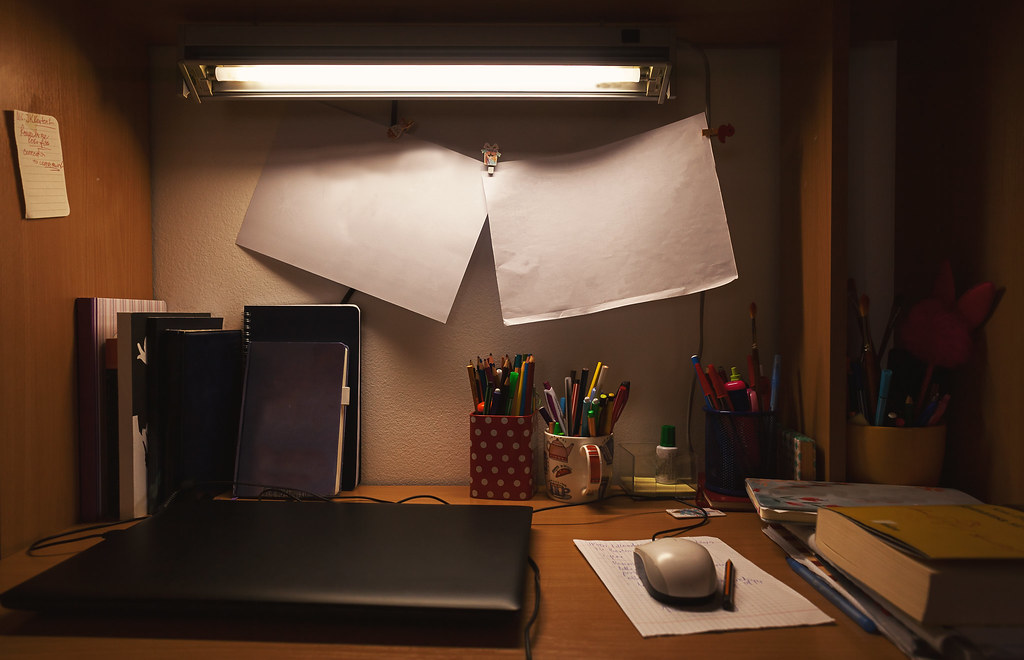 A home workspace with a notebook, pen and planning notes laid out on a desk